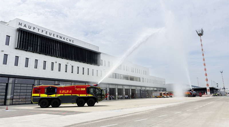 Flughafen Düsseldorf weiht eine der modernsten Feuerwachen Europas ein - Titelbild: Standesgemäße Einweihung für eine der modernsten Feuerwachen Europas: „Wasser marsch!“ hieß es bei der Eröffnungsfeier. Mit Wasserfontänen aus zwei Panther-Löschfahrzeugen feierten die Feuerwehrleute des Airports ihr neues Einsatzgebäude. Rund 100 Gäste nahmen an der offiziellen Einweihung teil. (Foto: Flughafen Düsseldorf / Andreas Wiese)